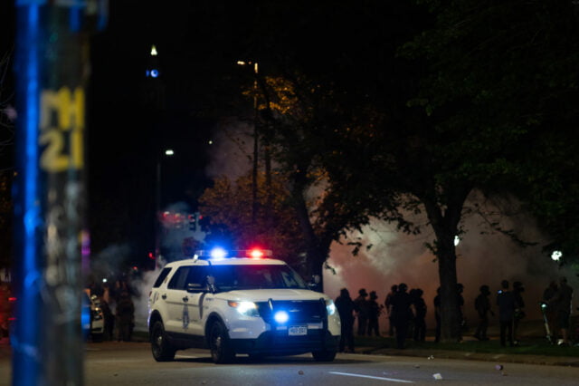 Police vehicle parked with lights on.