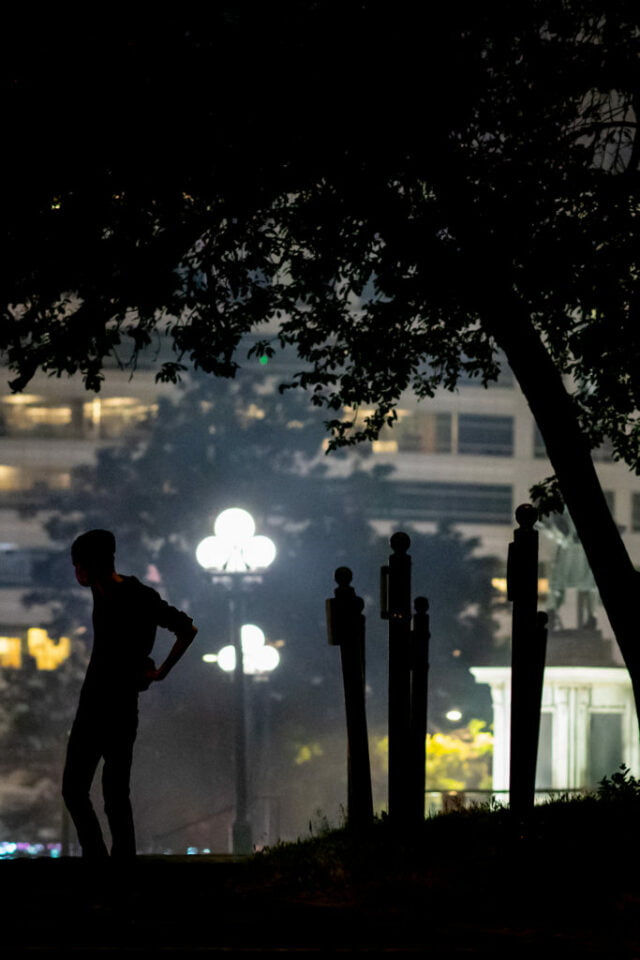 Single figure in silhouette in park.