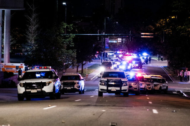 Seven police vehicles with their lights off approaching.