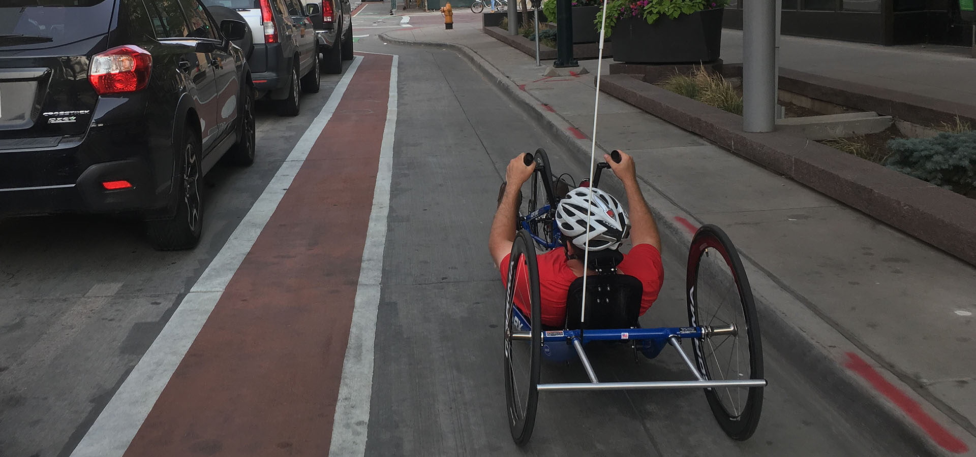 Recumbent cycylist approaches an intersection in the bike lane along side traffic