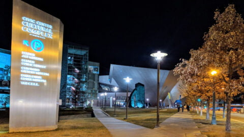 outside of the civic center cultural complex at night. directional sign showing parking location
