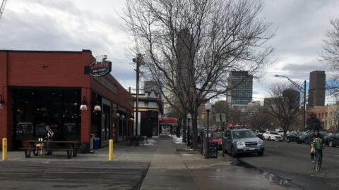 Busy corner of 17th and Clarkson showing shoppers, cyclists, and traffic