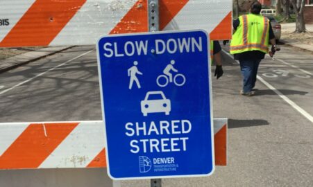 Photo of a traffic control sign stating that this street should be shared with bikes, people, and cars