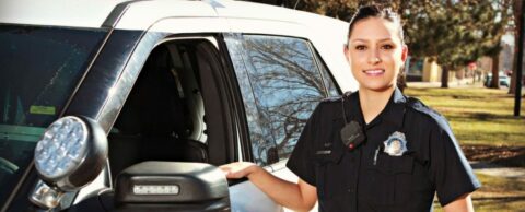 Female Denver Police officer standing next to her police vehicle