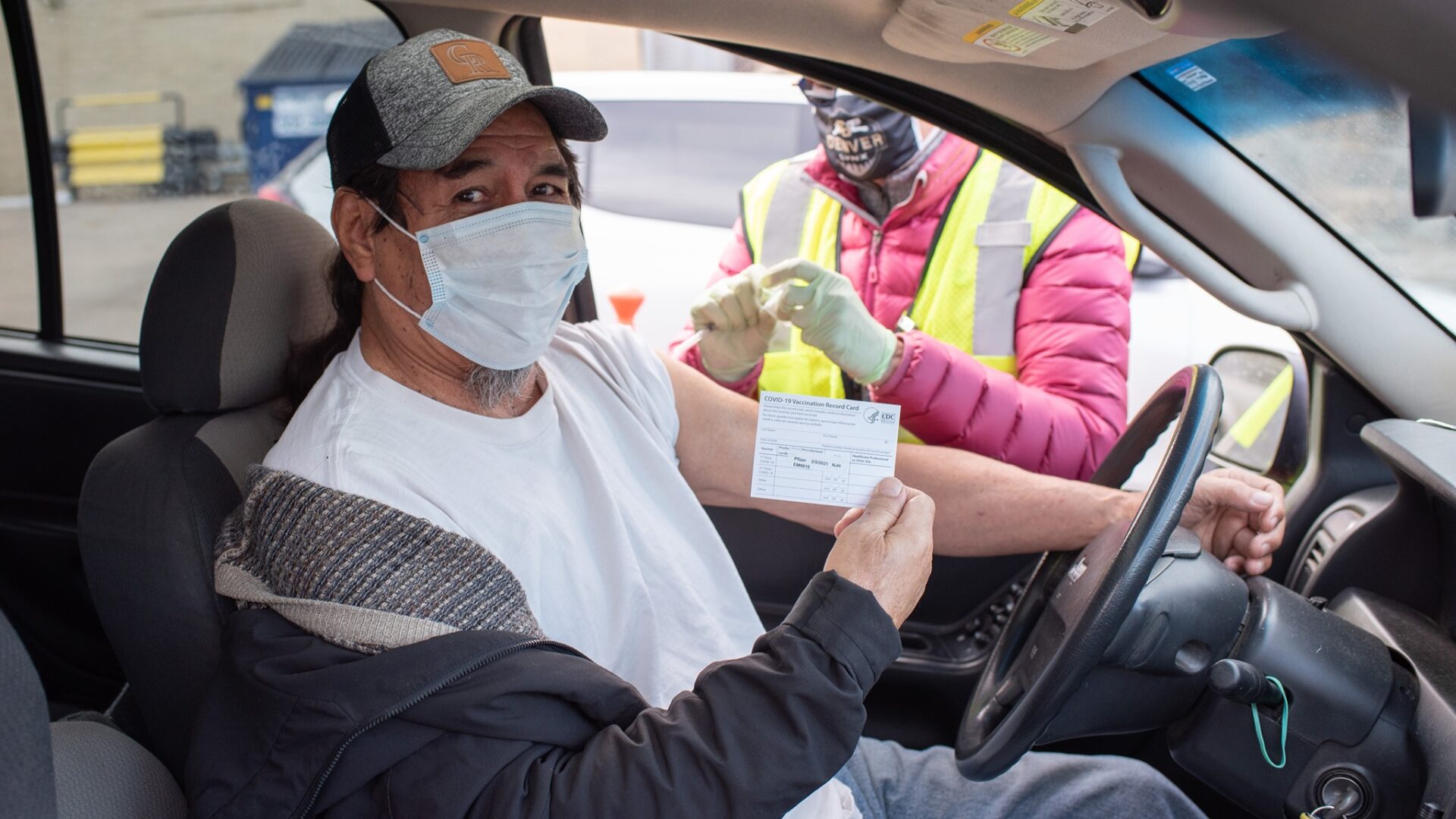 Man receiving a COVID-19 vaccine at a mobile drive-thru clinic.